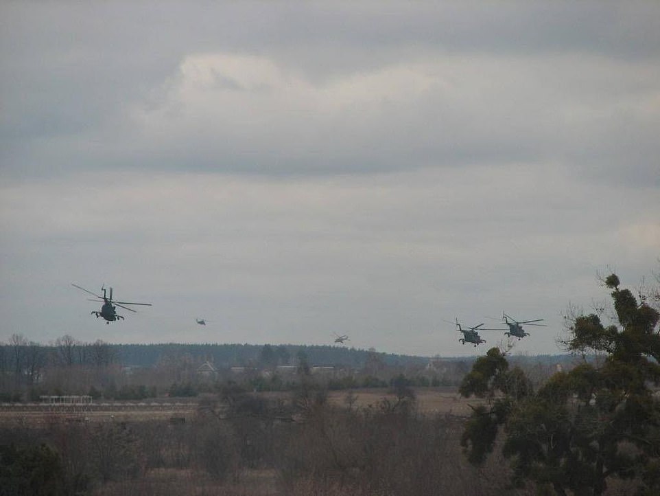 Shock helicopters are depicted flying over the Kiev region of Ukraine after dozens of Russian planes attacked the city