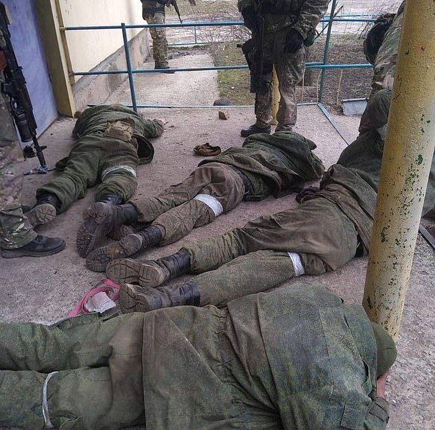 The crew of a Russian BMP war machine is seen face down with jackets over their heads