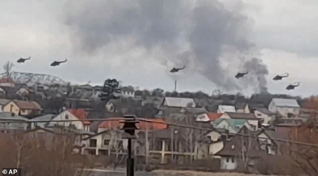 In this photo, taken from a video published by the press service of the Ukrainian police, military helicopters, apparently Russian, fly over the outskirts of Kiev, Ukraine