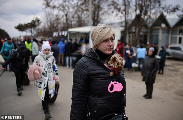 A small dog accompanies a Ukrainian refugee as they arrive at the border crossing in Siret, Romania today