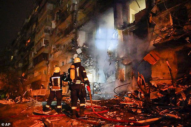 Ukraine and Russia agreed to hold peace talks on Monday at the border with Belarus, although Ukrainian President Volodymyr Zelensky admitted he wasn't confident of a positive resolution (Pictured: Firefighters inspect the damage at a building following a rocket attack on the city of Kyiv on Friday)