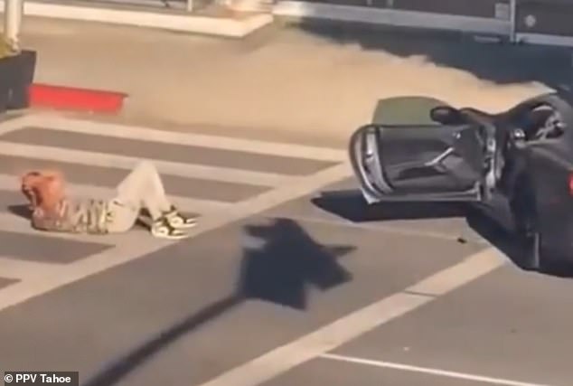 The unnamed victim is seen in a screenshot lying wounded in the middle of the street, just a few steps from his luxury car.