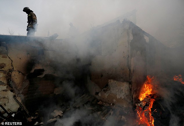 Firefighters deal with a house fire after the recent shelling in the separatist-controlled city of Donetsk, Ukraine, as the conflict rages for five days