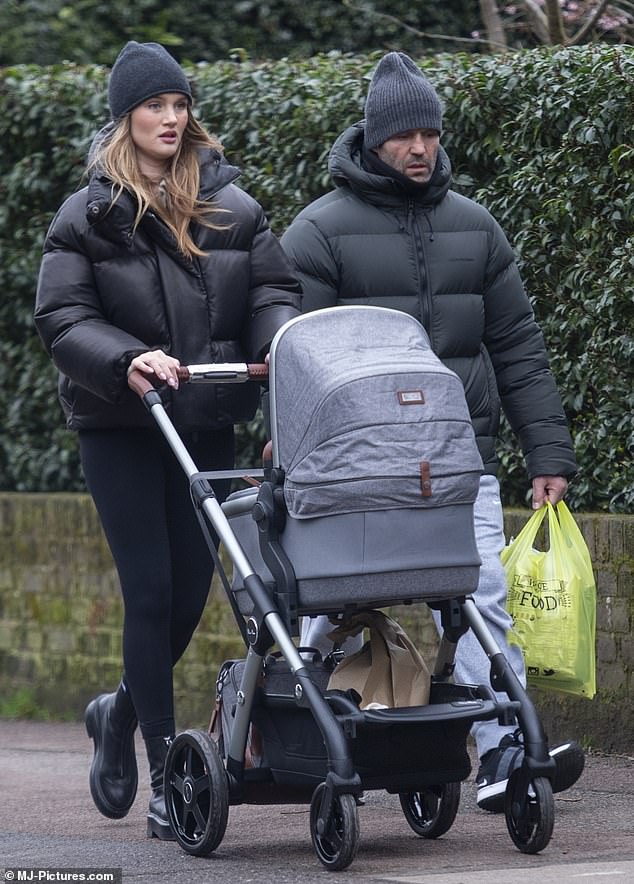 34 year old Rosie Huntington Whiteley wraps herself in a down coat and