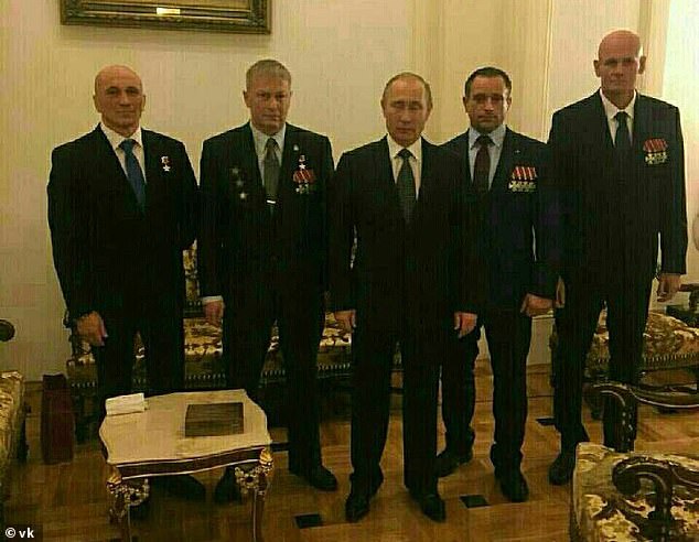 Vladimir Putin poses with four alleged Wagner officers serving in the Kremlin - who denies any involvement in Russian mercenary groups