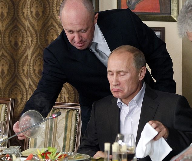 Evgeny Prigogine, left, serves food to Russian Prime Minister Vladimir Putin during a dinner at Prigogine's restaurant near Moscow in 2011.