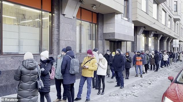 ATMs are being emptied, dollars are running low, and inflation is rising as international sanctions against Russia pay off.  In the photo: Russians line up to withdraw their money from ATMs