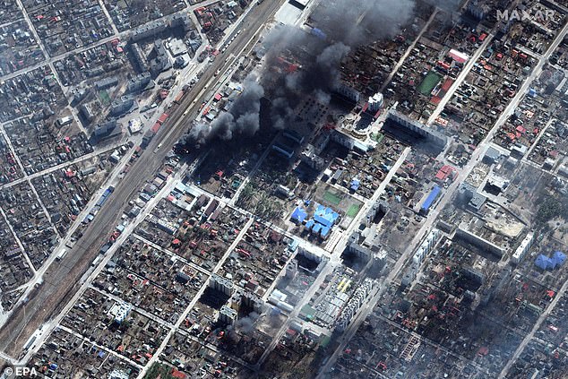 Satellite imagery provided by Maxar Technologies shows damage and burning buildings in Irpin, near Kyiv, Ukraine on Monday as the invasion approaches a month of fighting.