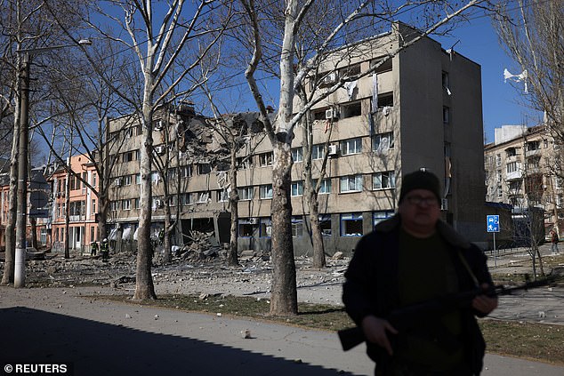 Aslin's partner, for whom he moved to Ukraine, was from Nikolaev, which was heavily attacked by Russian troops trying to reach Odessa.  Pictured: A Ukrainian soldier guards a building damaged by a military strike as the Russian invasion of Ukraine continues, Mykolaiv, Ukraine, March 21, 2022.