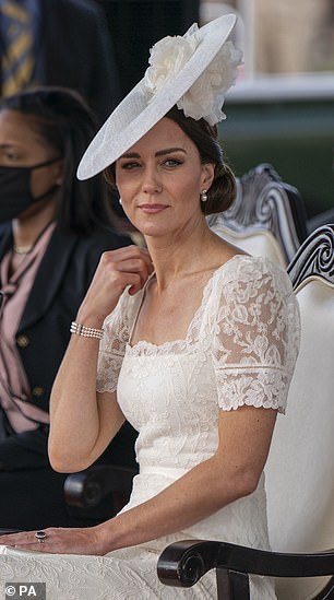 While Her Majesty wore a black tulle hat with three white feathers, the Duchess opted for an all-white floral headpiece.