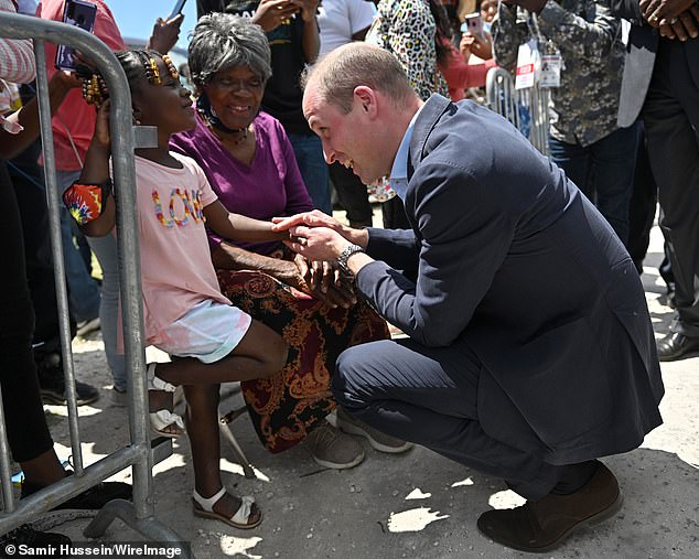 William interacted with several locals, including a little girl whom he held by the hand as she stood next to a seated elderly lady.