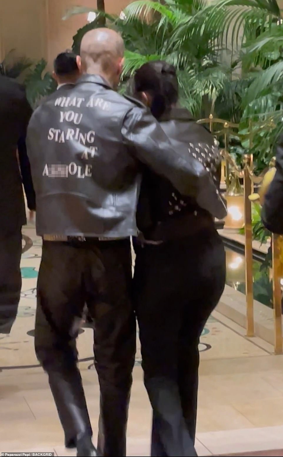 It takes two: Travis kept his arm around Kourtney as they made their way down the path to the lobby doors, though after a few steps she was more stable