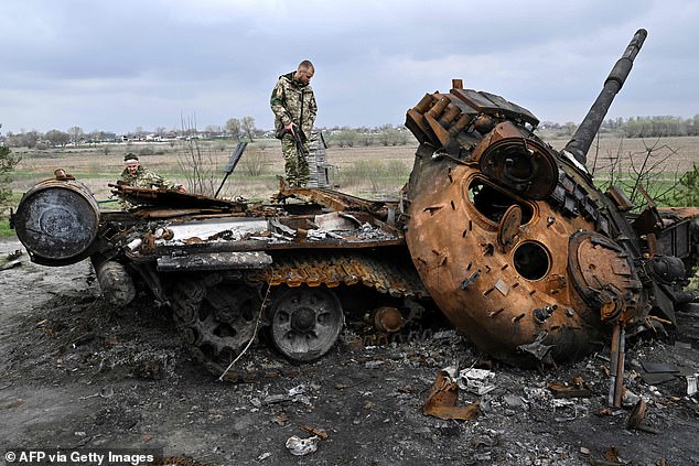 Russian forces are advancing at a snail's pace in Ukraine as commanders' maps are half a century old and their weapons are misfiring, Western officials said yesterday.  Above: A Ukrainian soldier stands on a destroyed Russian tank