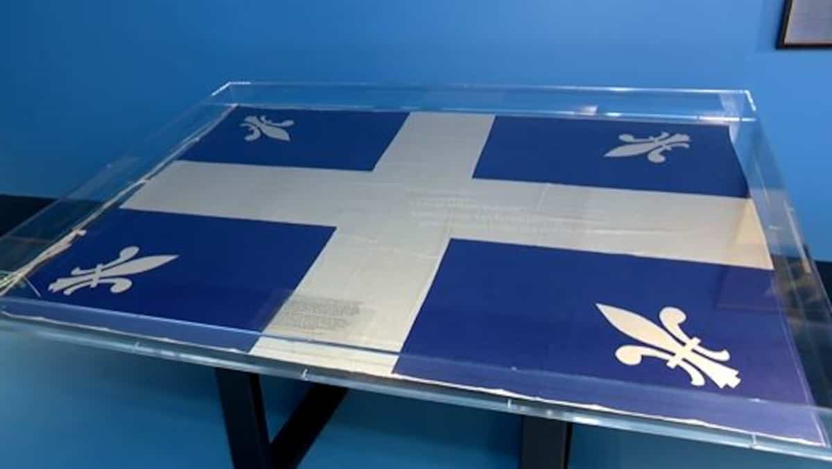 A new fleur de lis flag is raised for the 75th anniversary