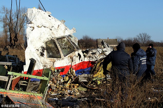 FILE PHOTO: Local workers transport a piece of wreckage from Malaysia Airlines flight MH17 to the site of the plane crash near the village of Hrabove (Grabovo) in the Donetsk region of eastern Ukraine November 20, 2014