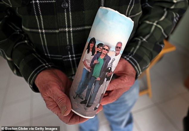 Linda Robinson is pictured left.  Her father Joseph Hachey holds up a photo of his family, including a young Sebastian, and his wife Claudette on a Cape Cod beach