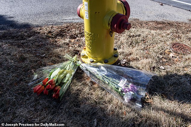 Flowers sit in front of the house where the double homicide and suicide took place