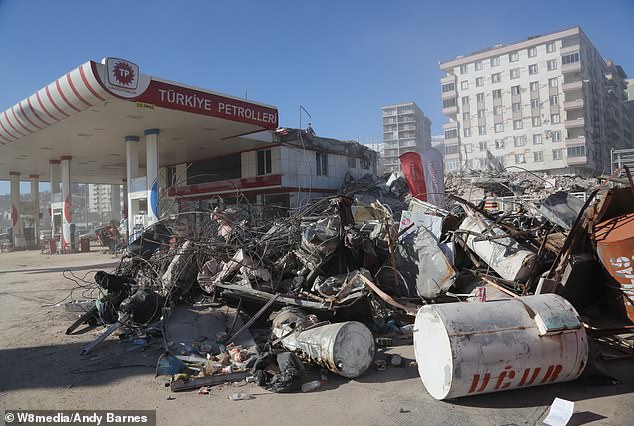 Police officers and soldiers with assault rifles guarded the scene of the devastation next to a gas station