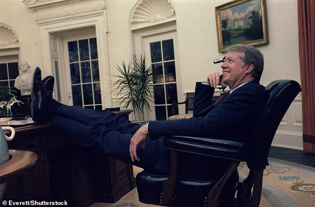 President Jimmy Carter sits with his feet up on the Resolute Desk in the Oval Office of the White House