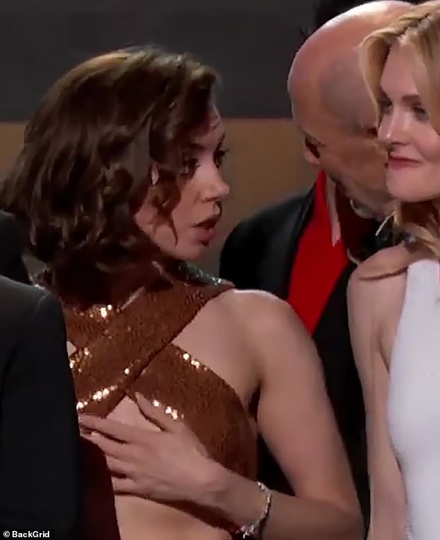 Actor Jon Gries leaned in to whisper something in Aubrey's ear, after which she was seen cupping her hands to her chest before frantically rearranging her Michael Kors dress