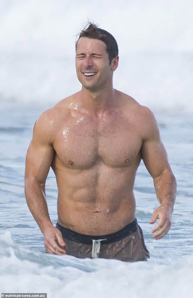 Lead actor Glen Powell (pictured) also appeared in the scene, showing off his ripped physique as he went shirtless in a pair of brown and black swim trunks