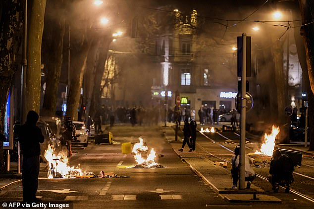 Rubbish burns on the streets of Lyon on Monday night after the government pushed a pension reform without a vote through parliament