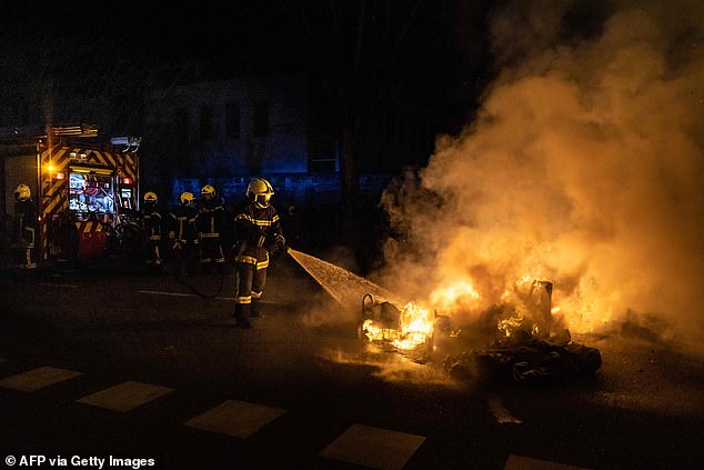 A firefighter begins putting out a blaze during a demonstration in Dijon on Monday night