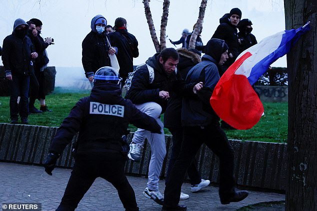 A police officer clashed with protesters at a demonstration in Lille, France today, as lawmakers took part in votes on pension reforms and distrust of Emmanuel Macron's government