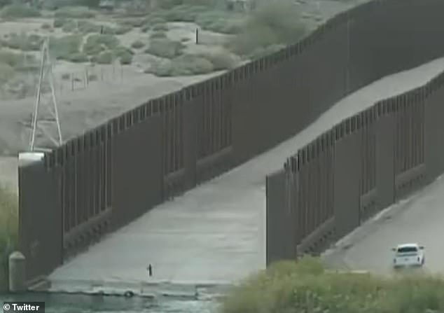 The child is completely alone at the border.  A patrol car spots him through the fence