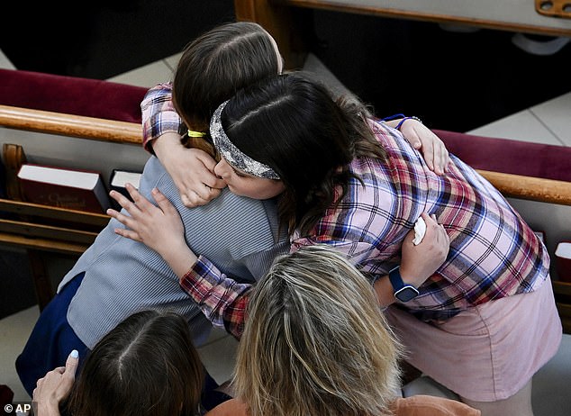 Two girls hug at a prayer vigil at Woodmont Christian Church for the victims of the mass shooting