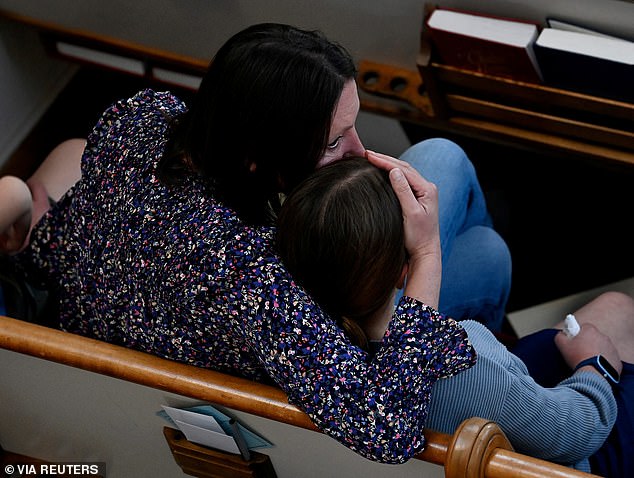 A woman hugs her daughter during a prayer vigil Monday night