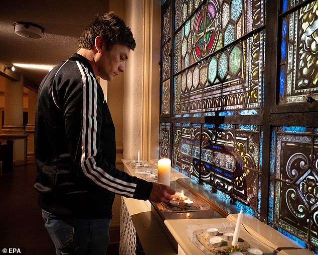 Nashville's Skyler Bush lights a candle during a vigil at Belmont United Methodist Church