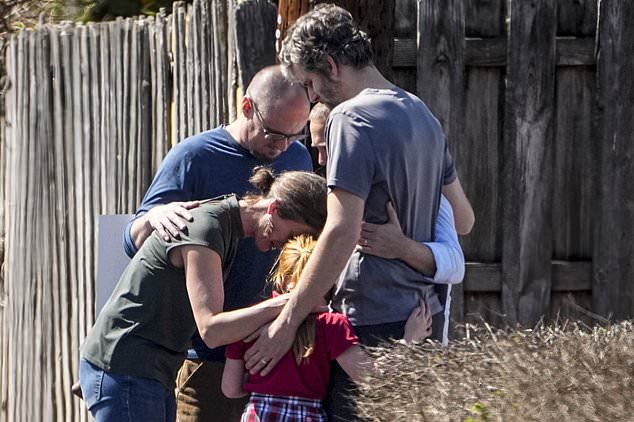 A group prays with a child outside the reunion center at Woodmont Baptist Church following the school shooting