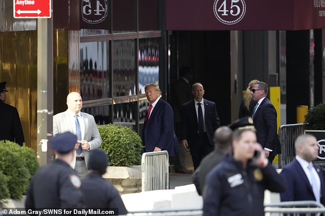 Trump looks toward the crowd as he enters a Trump Tower entrance less than 24 hours before his court appearance in the Stormy Daniels hush money case