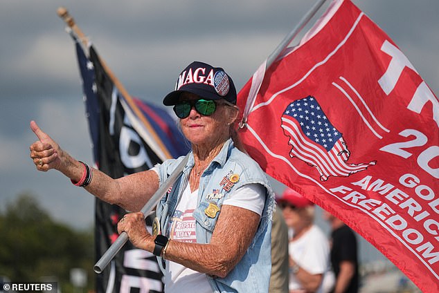 A member of his MAGA cronies gives a thumbs up as she waits for the ex-president to walk by