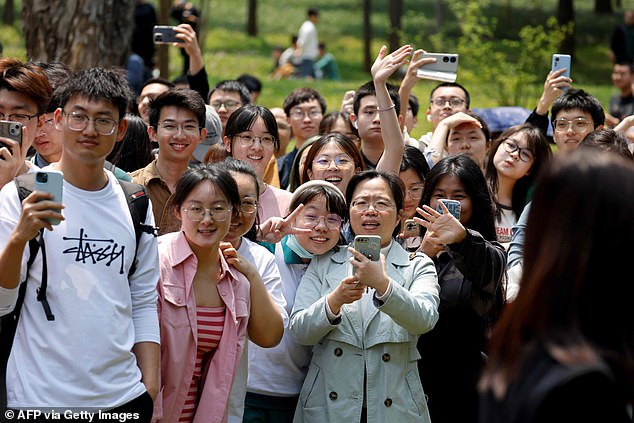 Chinese students await the arrival of French President Emmanuel Macron at Sun Yat-sen University in Guangzhou, April 7, 2023