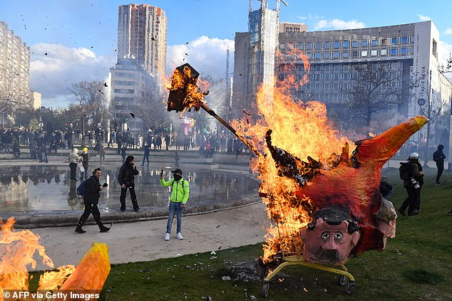 An effigy of the French President burns during a demonstration at Place d'Italie on the 11th day of action after the government on March 6