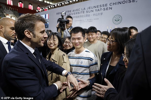 French President Emmanuel Macron (L) meets and speaks with Chinese students during his visit to Sun Yat-sen University in Guangzhou April 7, 2023