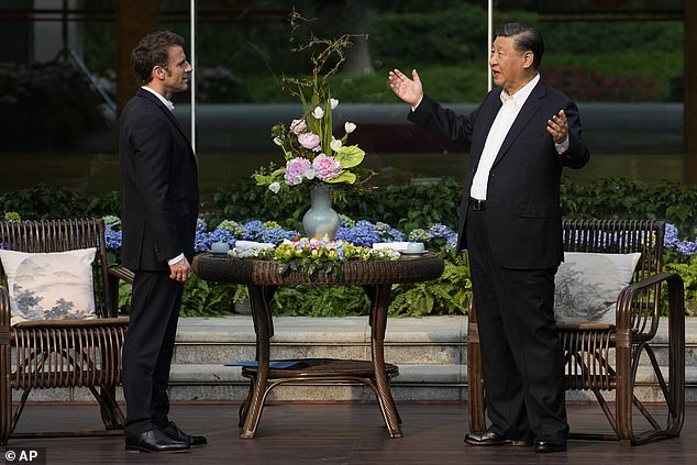 Chinese President Xi Jinping (right) and French President Emmanuel Macron chat before a tea ceremony at the residence of the Guandong provincial governor in Guangzhou, China, Friday April 7