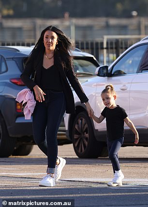 Davina and Mila-Mae are seen here holding hands for security as they cross the parking lot