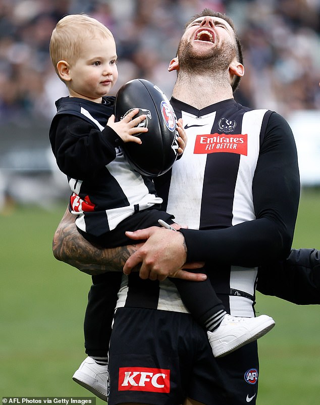 The Collingwood star cuddled with the toddler, who will turn two in August, while the couple played some games at Melbourne Cricket Ground