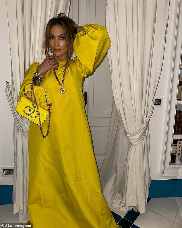 Glamorous!  Jennifer wore a gorgeous yellow satin dress with a matching chain-strap bag as she made a splash in her latest post