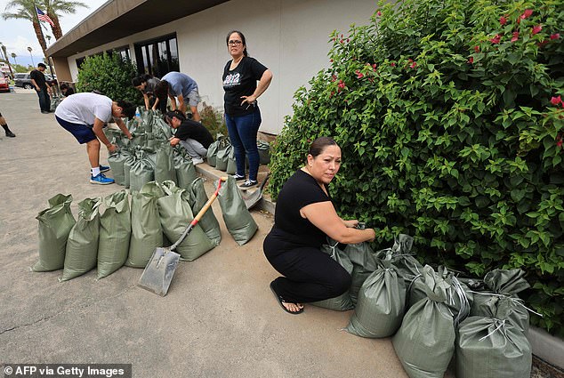 Residents prepare sandbags provided by the City of Indio in a library lot as Hurricane Hilary's path heads north toward Southern California