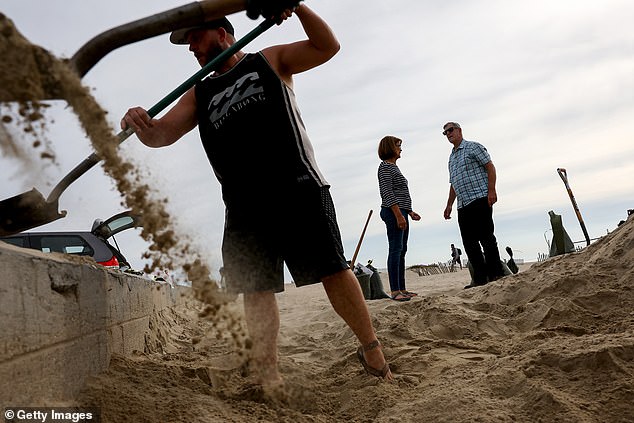 People shovel sand into sandbags from Seal Beach as Hurricane Hilary approaches