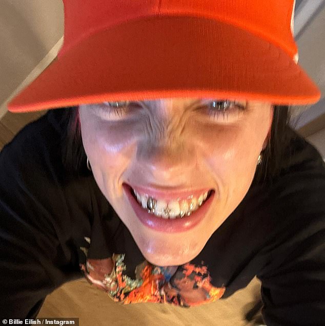 Diamond Grills: The star flaunted her look in a close-up selfie as she wore a graphic tee and orange hat