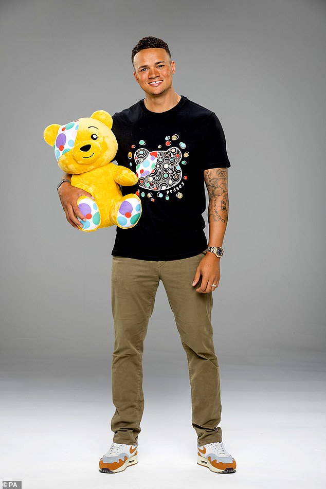 Looking good: The One Show's Jermaine Jenas wore a black T-shirt and snuggled up to the charity's famous mascot