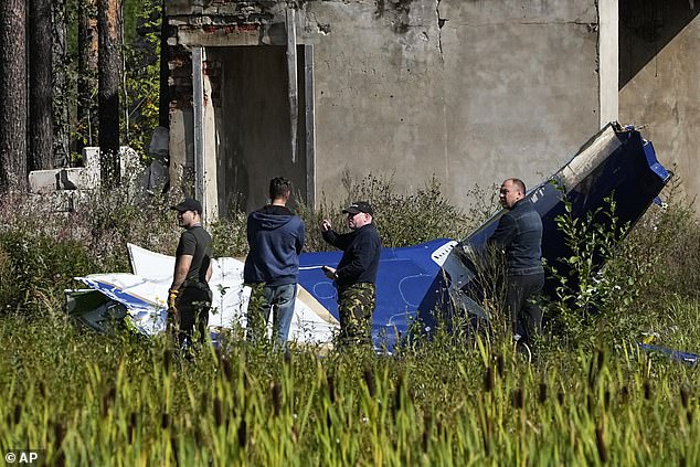 The Embraer chief jet then crashed to Earth, killing Prigozhin, his bodyguards and other Wagner commanders.  Pictured: - Russian investigators search the scene of a plane crash near the village of Kuzhenkino on August 24 this year