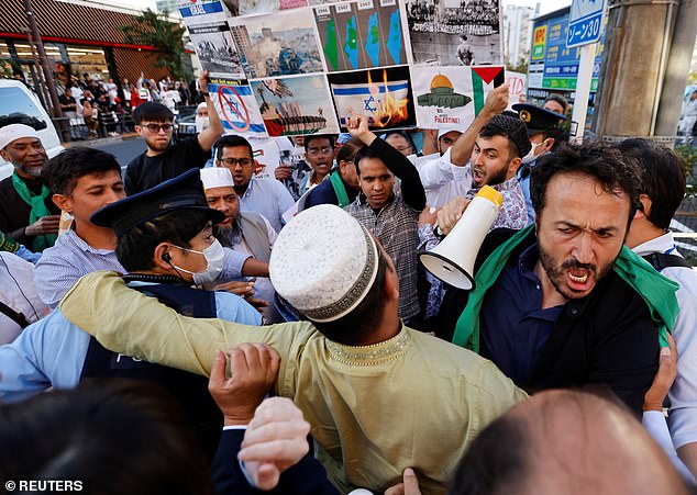 JAPAN: Police officers jostle with members of the Muslim community in Japan during a rally in support of Hamas on Friday