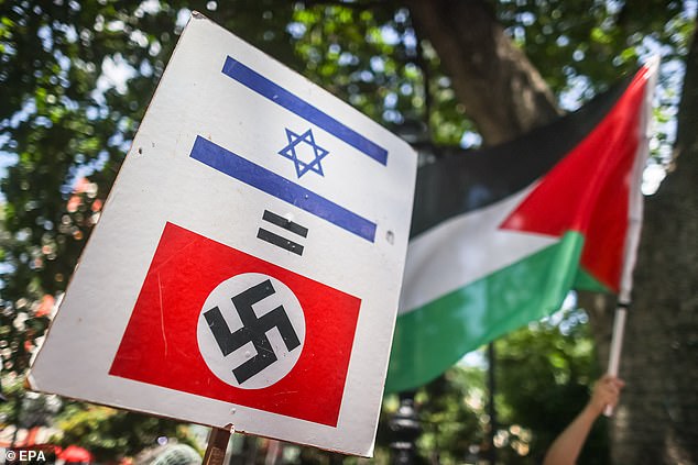 A poster with the Israeli and Nazi flags is seen during a demonstration in support of the Palestinian people in Caracas, Venezuela