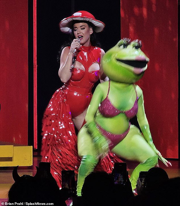 Racy: The Part of Me singer wears a red latex bodysuit with sexy cutouts for her costume as a giant mushroom